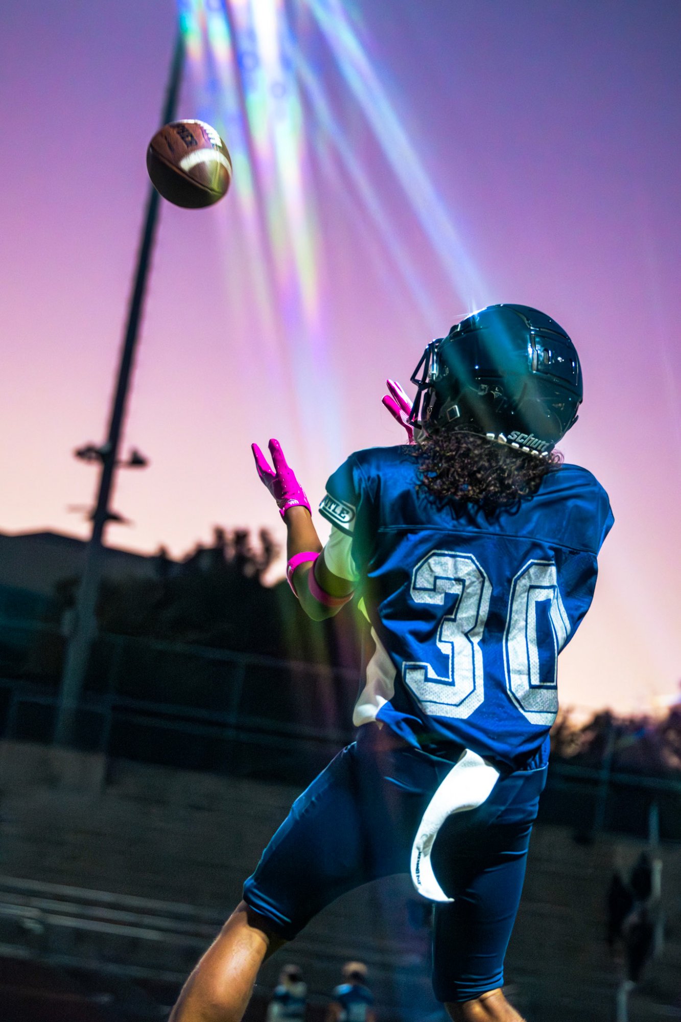 Player catching ball at sunset