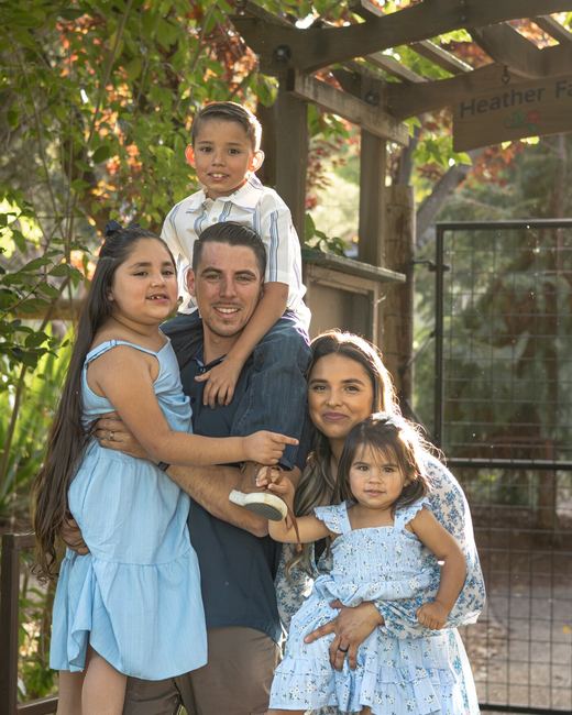 Family of five hugging together outdoors