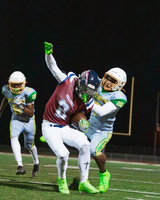 Multiple defenders making a night tackle