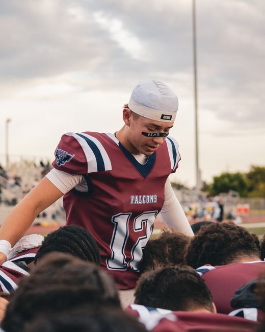 Quarterback leaning into the huddle