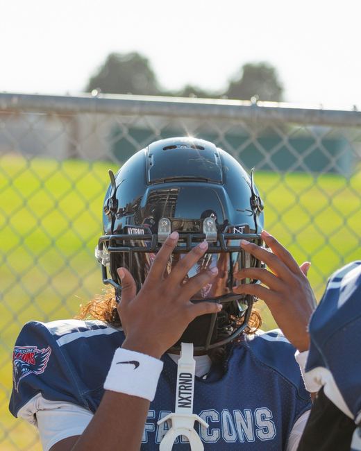 Football player adjusting his helmet