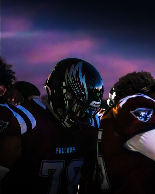 Football player in helmet under a purple sky