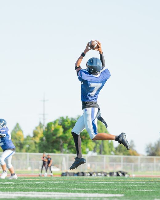 Football receiver leaping to catch the ball