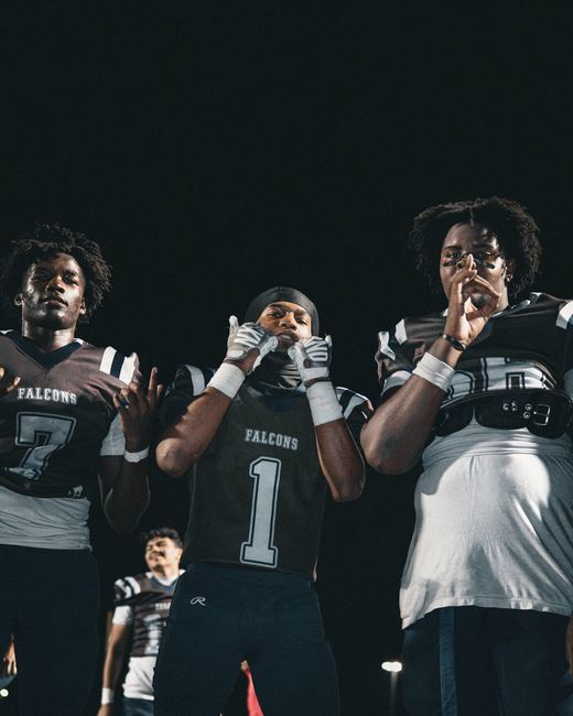 Three players posing together at a night game