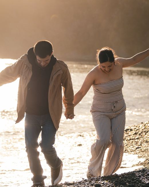 Couple walking hand in hand along the shore