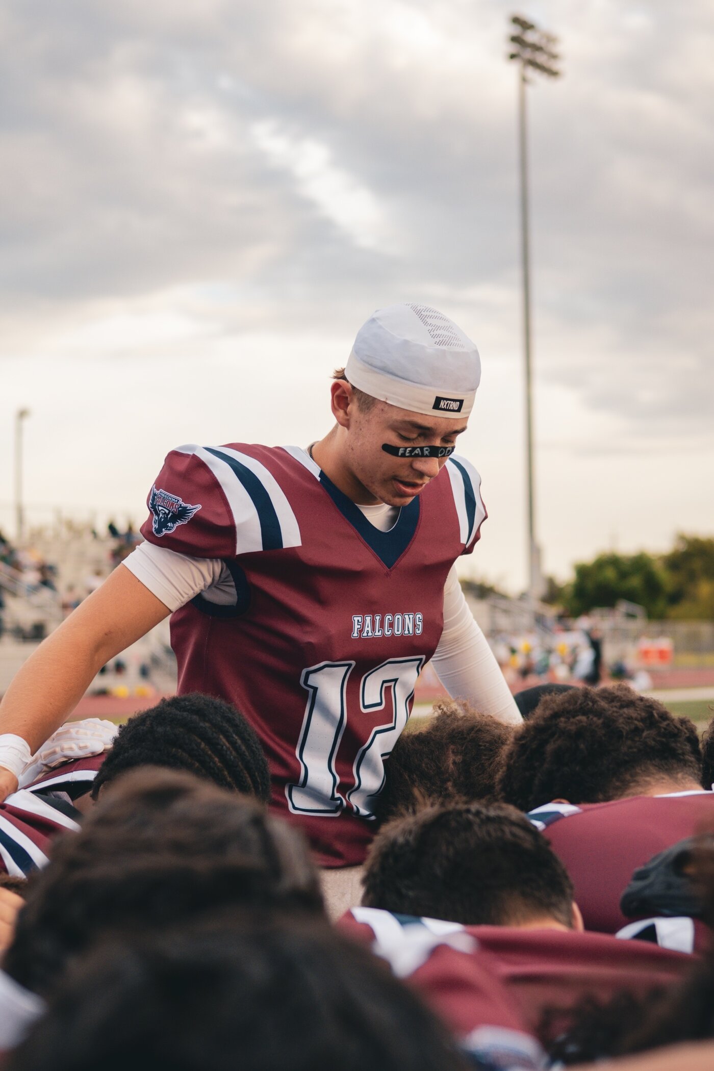 Quarterback leaning into the huddle
