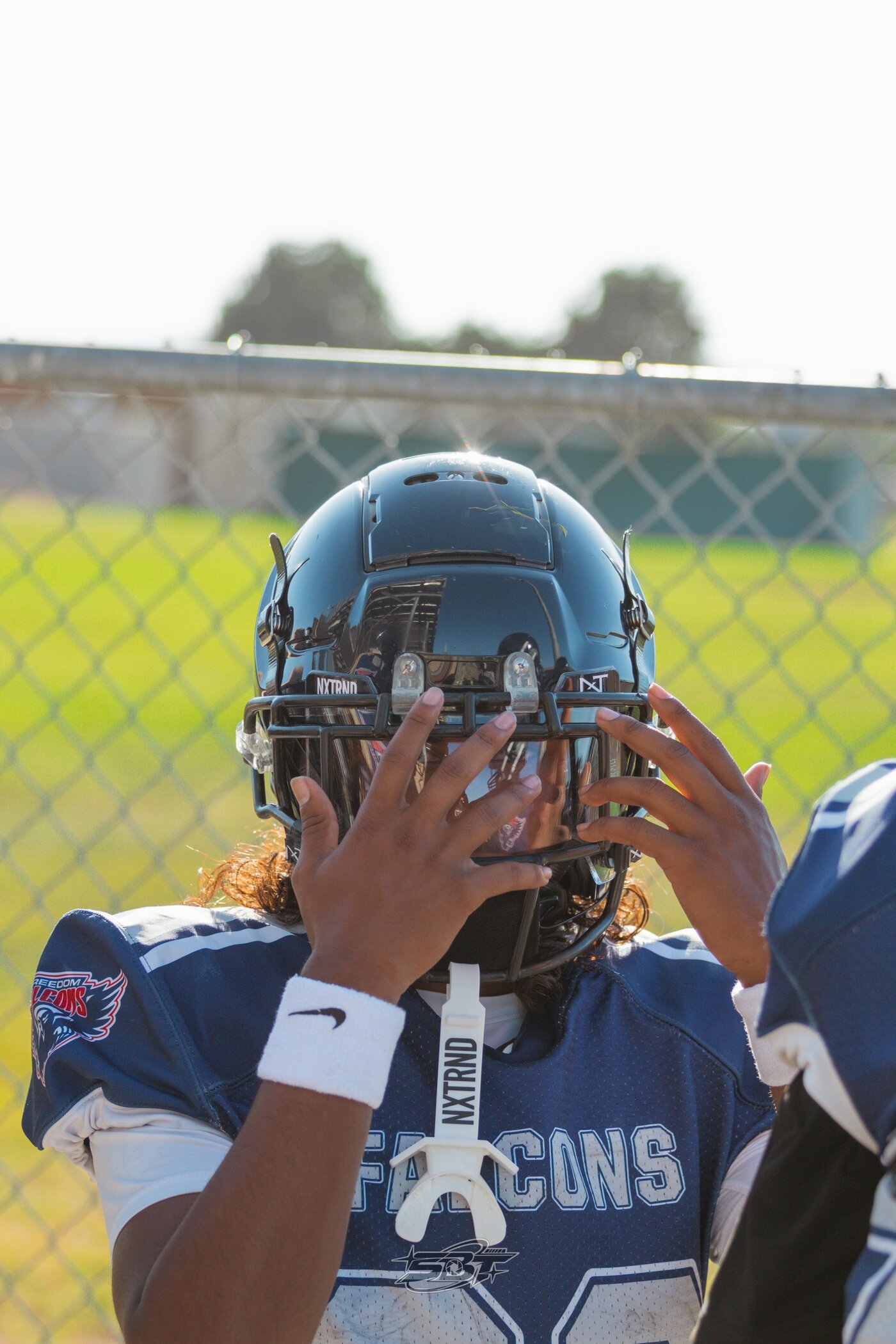 Player adjusting helmet and mouthguard