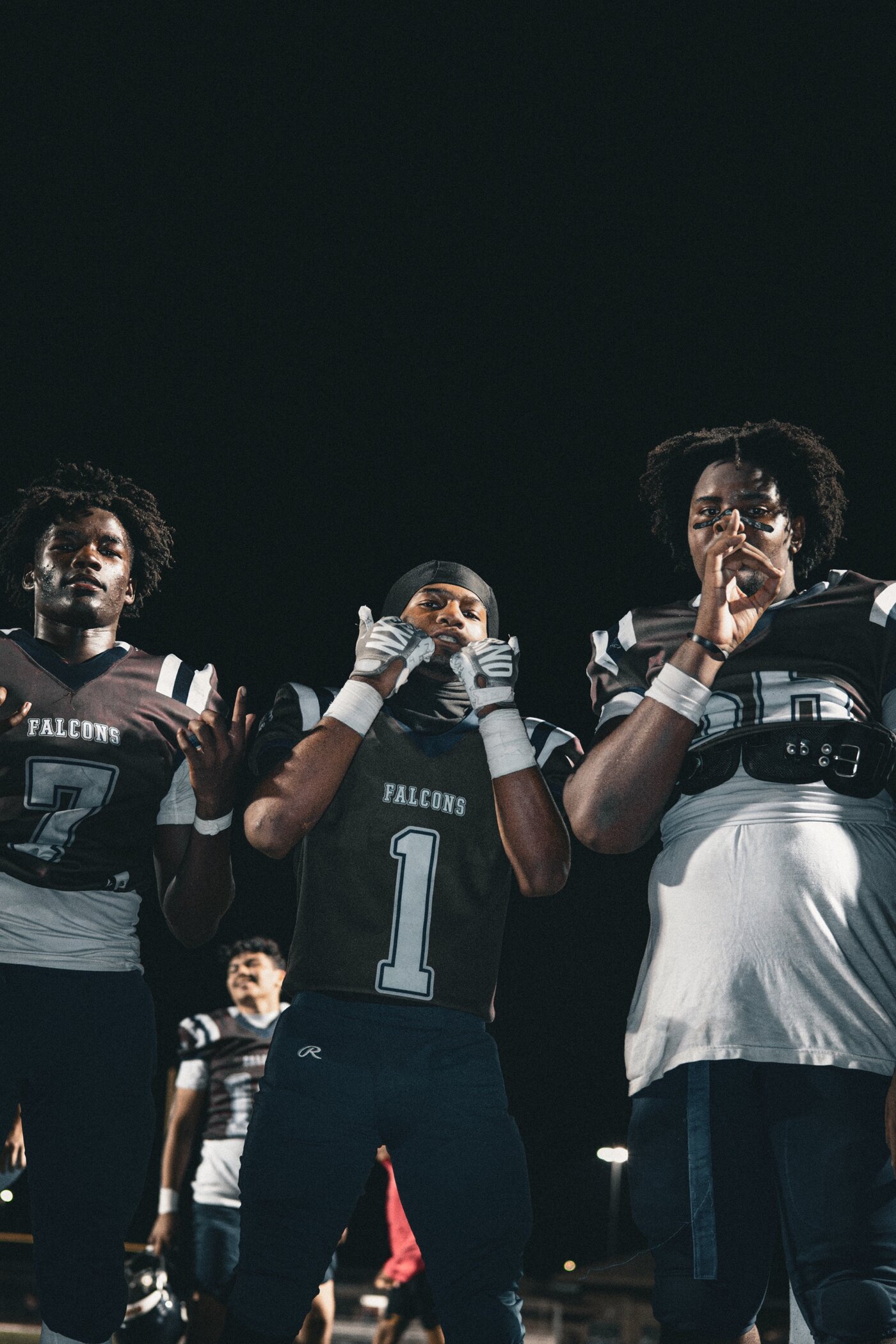 Three players posing together at a night game