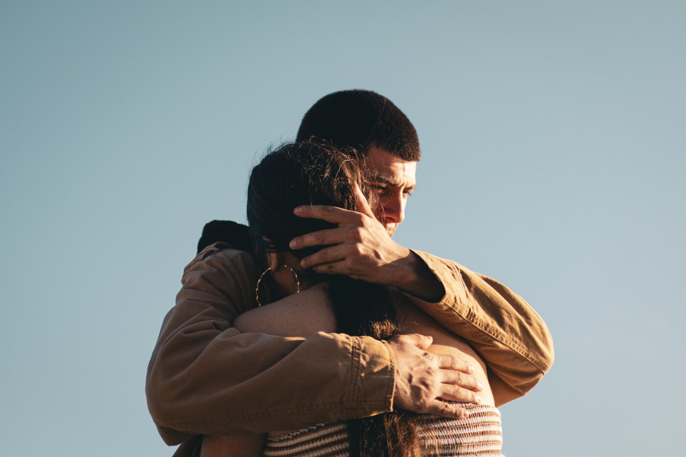 Couple embracing against the sky
